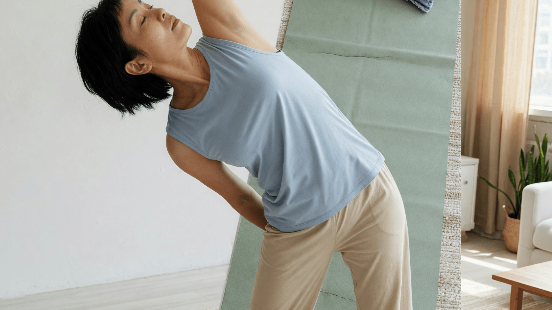 Une femme aux cheveux courts réalise une flexion latérale debout dans un salon, un bras levé.