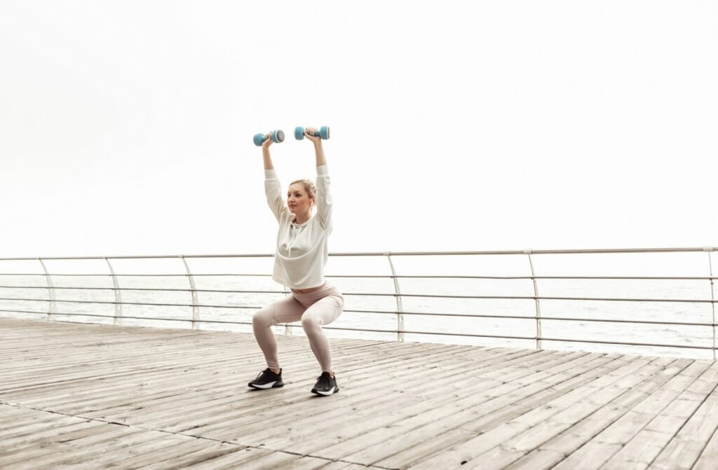 Exercice squats jambes bras haltères