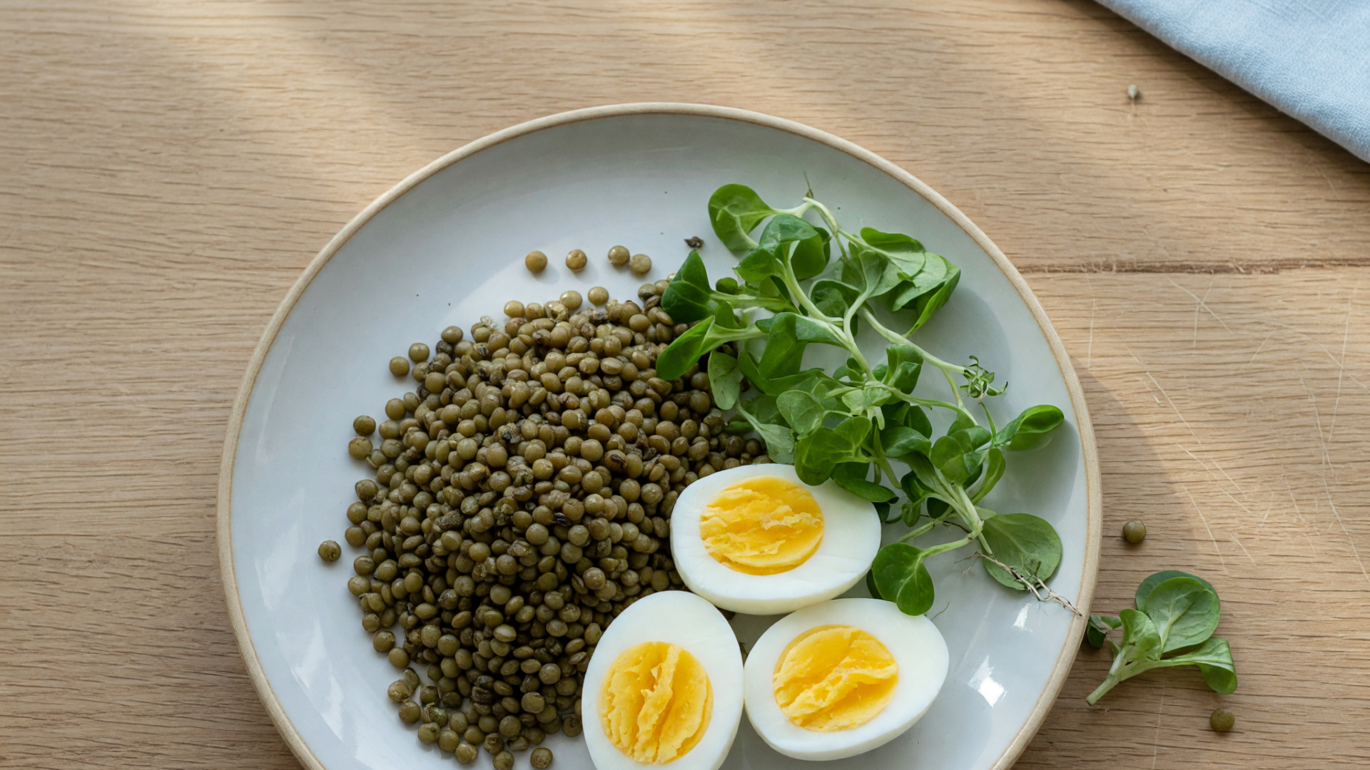 Assiette de lentilles, d’œufs durs et de pousses vertes.
